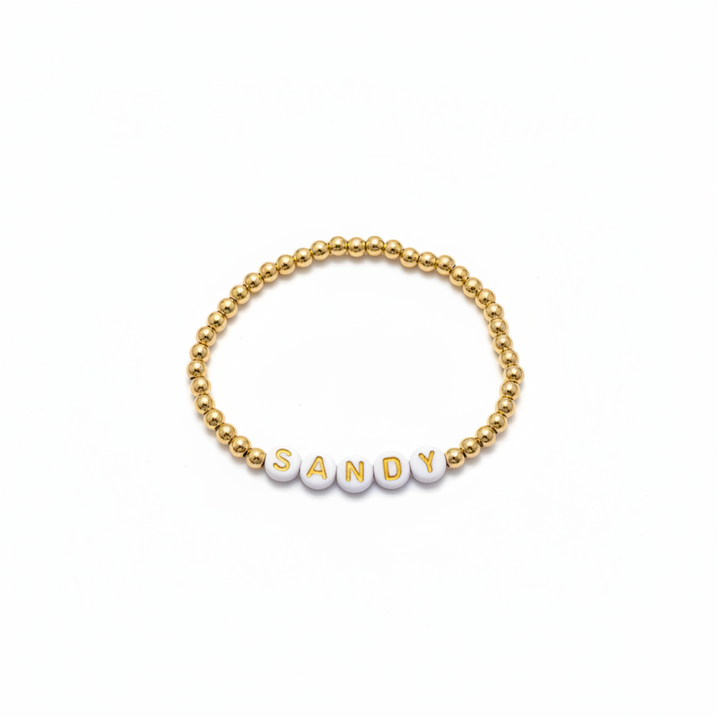 Gold beaded bracelet with personalized letter beads on white background